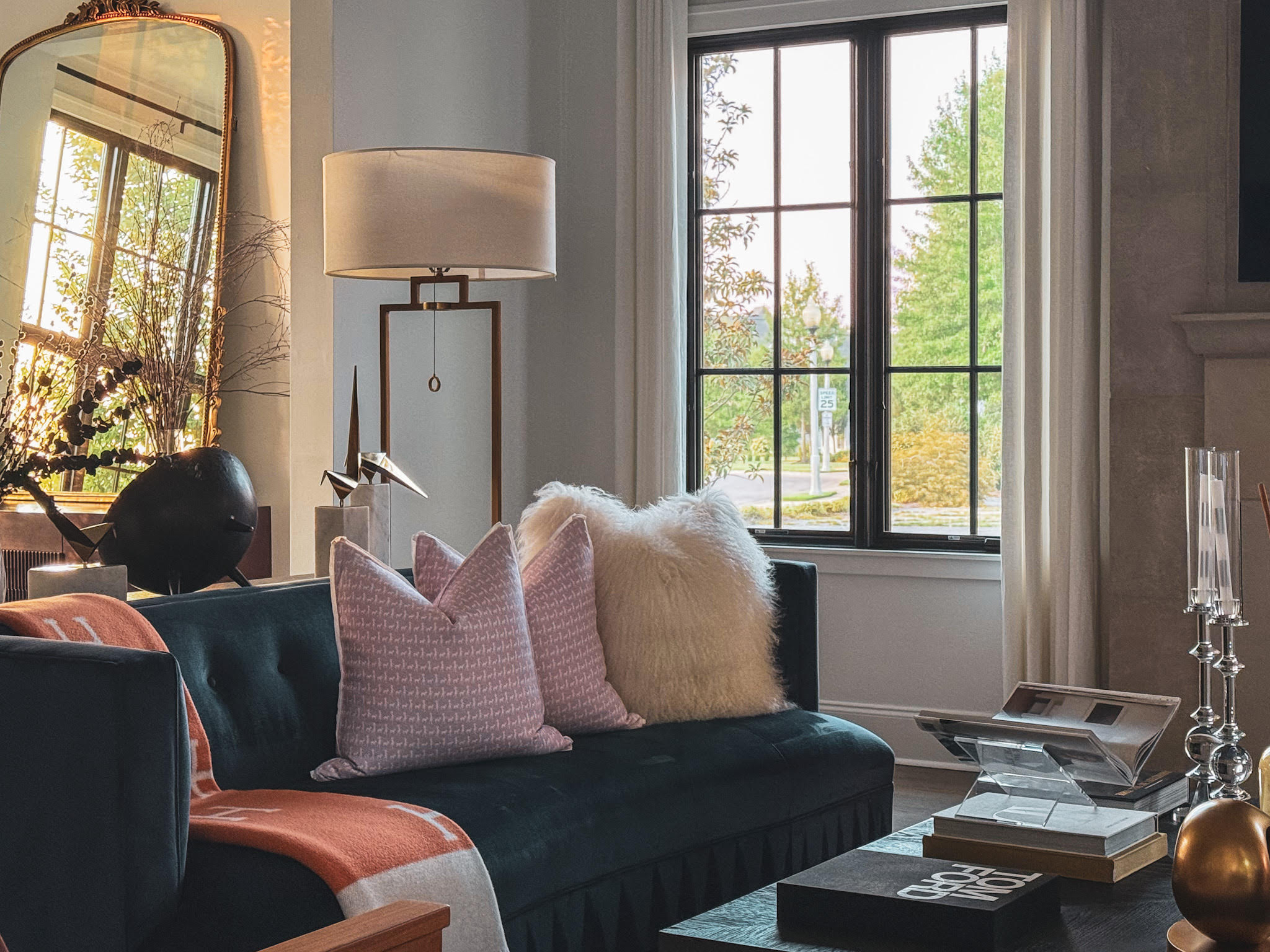 Curated studio study interior featuring bespoke wooden desk, statement chandelier, stone fireplace, and contemporary artwork